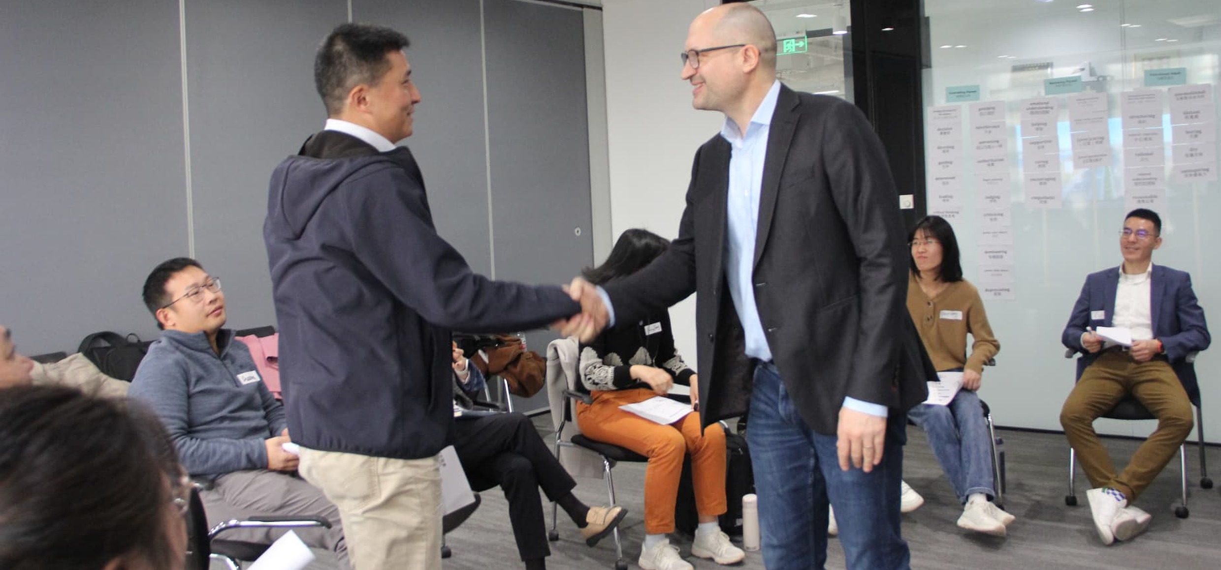 Workshop participants shaking hands during a facilitated session